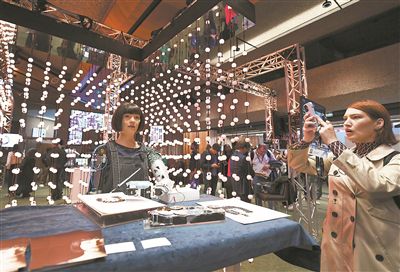 在瑞士日内瓦举行的2024年“人工智能造福人类全球峰会” 上，参会者用手机拍摄绘画艺术家机器人Ai-Da（资料照片）。新华社记者 连漪摄