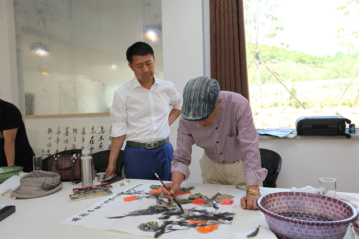 昌宇集团董事长李刚在昌宇水墨画院创作基地观看画家创作作品