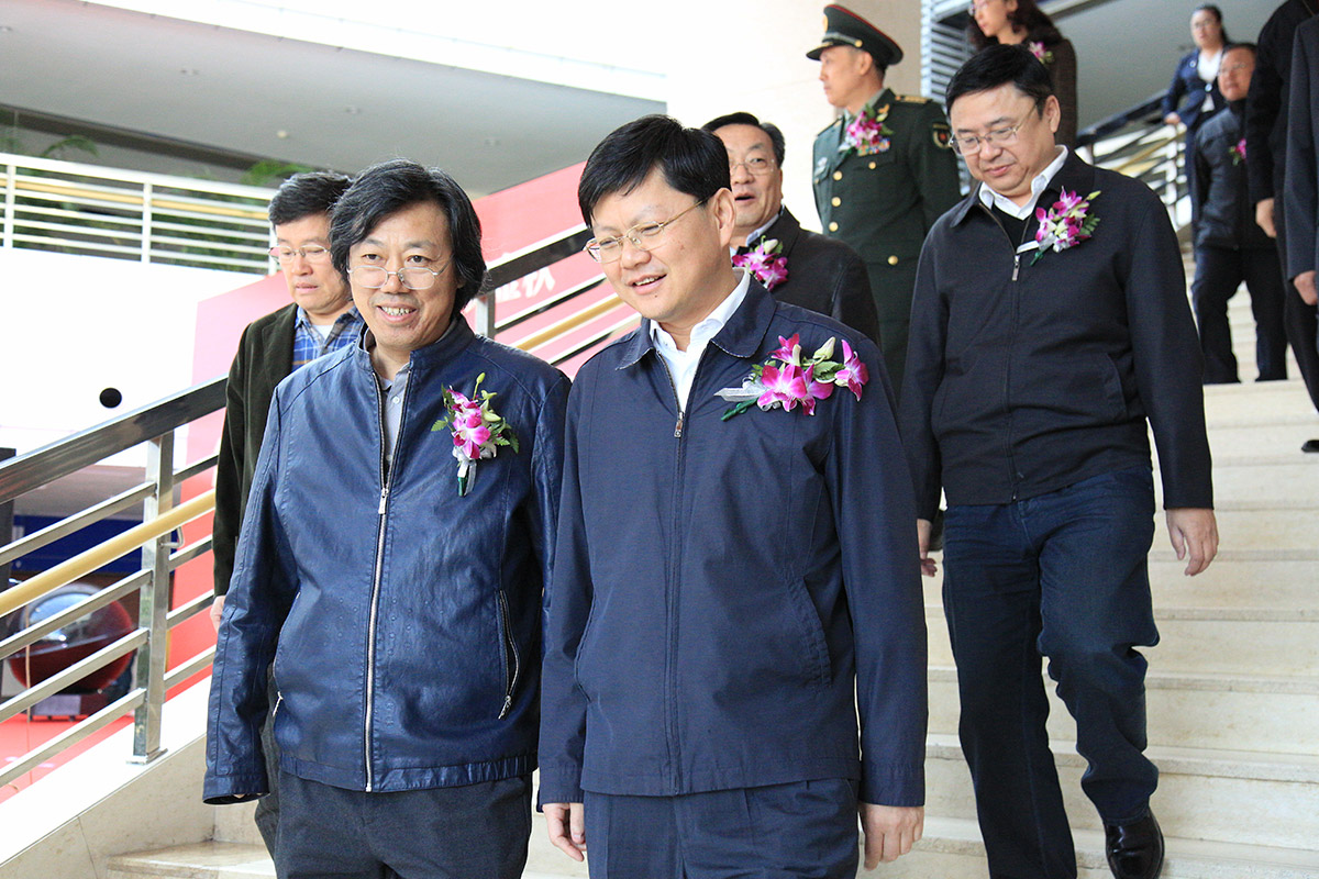 中国美术家协会艺术中心主任丁杰与营口市政府市长余恭斌正在进入画展开幕式现场