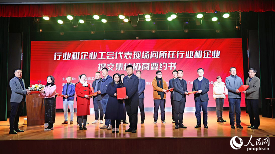 行业和企业工会代表向所在行业和企业提交集体协商要约书。人民网记者 陈博摄