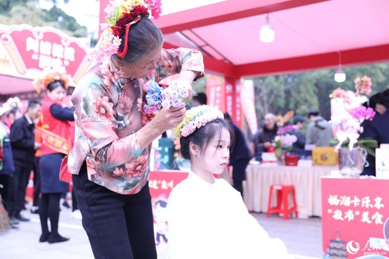 游客体验“簪花”,感受世遗文化魅力。人民网 李昌乾摄